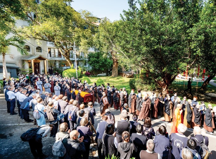 法鼓山僧俗四眾護送二師伯鑑心長老尼的靈柩，緩緩移出中華佛教文化館。（李東陽 攝）｜楊子佛教禮儀公司