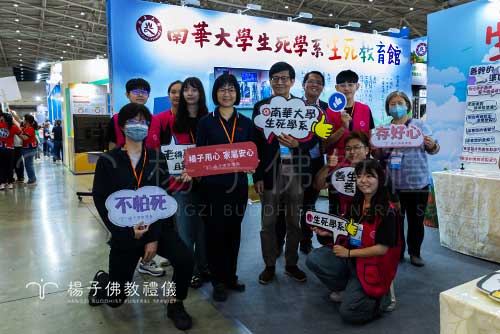 台北國際照顧博覽會的「生死教育館」前，楊子同仁與南華大學師生留下溫馨合影 。大家帶著熱情與使命，共同傳遞面對生死無常的智慧與新解方 。